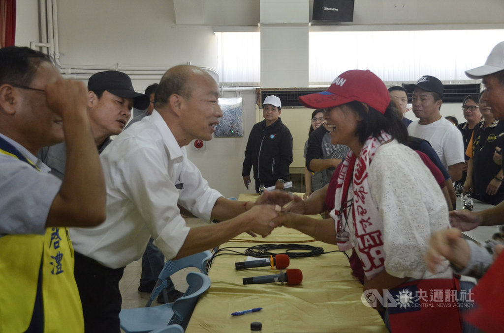 國民黨總統參選人韓國瑜(左白衣者)22日走訪嘉義縣海線多個鄉鎮市,行程中因群眾太熱情,韓國瑜握手時拇指受傷。中央社記者蔡智明攝 108年10月22日