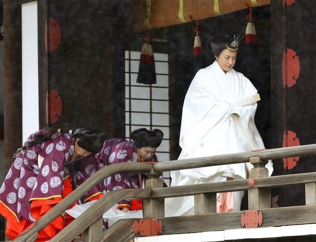 皇后雅子(右)身穿純白的「十二單」傳統服飾,髮型採用平安時代貴族女性「大垂髮」,完成在皇居內宮中三殿舉行的儀式。(共同社提供)