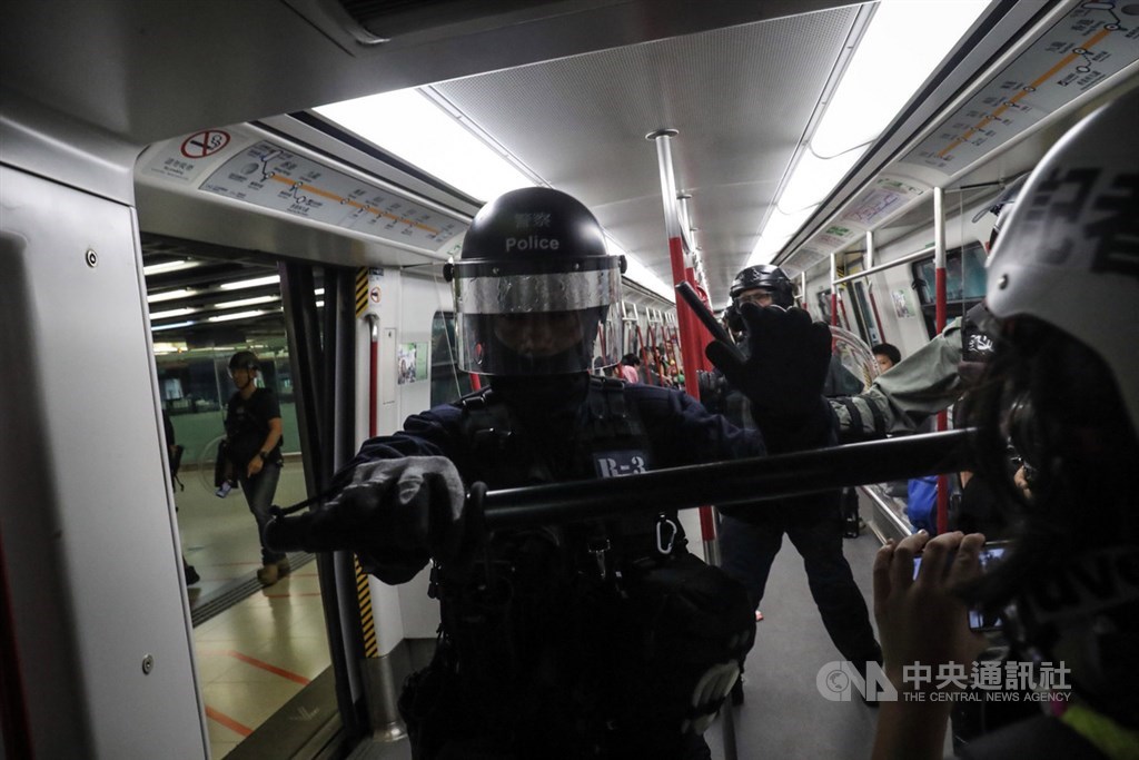 香港反送中運動延燒,港媒引述消息人士稱,若獨立監察警方處理投訴委員會的報告無法平息社會爭議,港府將考慮設獨立調查委員會。圖為港警進入地鐵列車盤查市民。(中央社檔案照片)