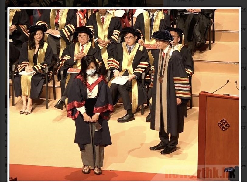 香港理工大學27日舉辦第25屆畢業典禮,有畢業生疑似為聲援「反送中」運動,戴口罩上台,校長滕錦光(前右)當場拒絕與畢業生握手合照。(圖取自香港電台網頁rthk.hk)