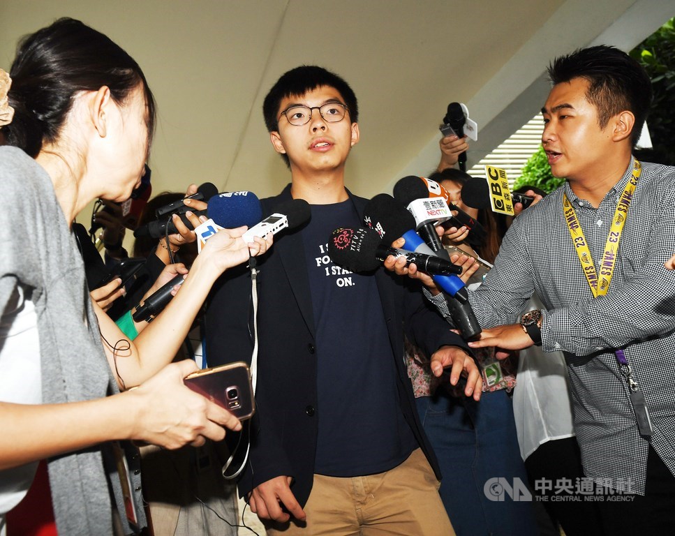 黃之鋒(中)26日晚間重申,「民主自決並非獨立,香港眾志亦無意改為主張香港獨立」。(中央社檔案照片)