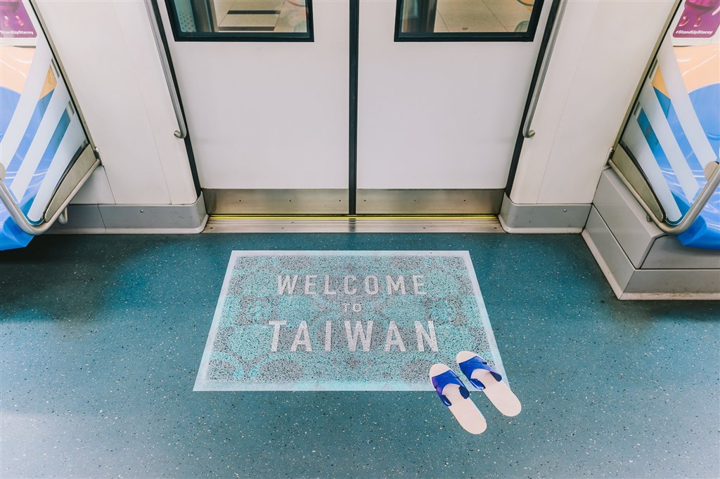 車廂入⼝擺放著一張以假亂真的迎賓墊,上面寫著WELCOME TO TAIWAN,再搭配家家⼾戶都有的藍⽩與紅白拖,象徵濃情歡迎到台灣的意象。(圖取自facebook.com/time.for.taiwan)