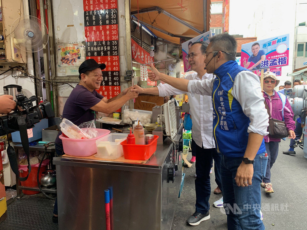 前新北市長朱立倫(前右2)31日陪同國民黨新北市第一選區立委參選人洪孟楷(前右)在淡水掃街,與攤商及民眾親切互動。中央社記者葉臻攝 108年10月31日