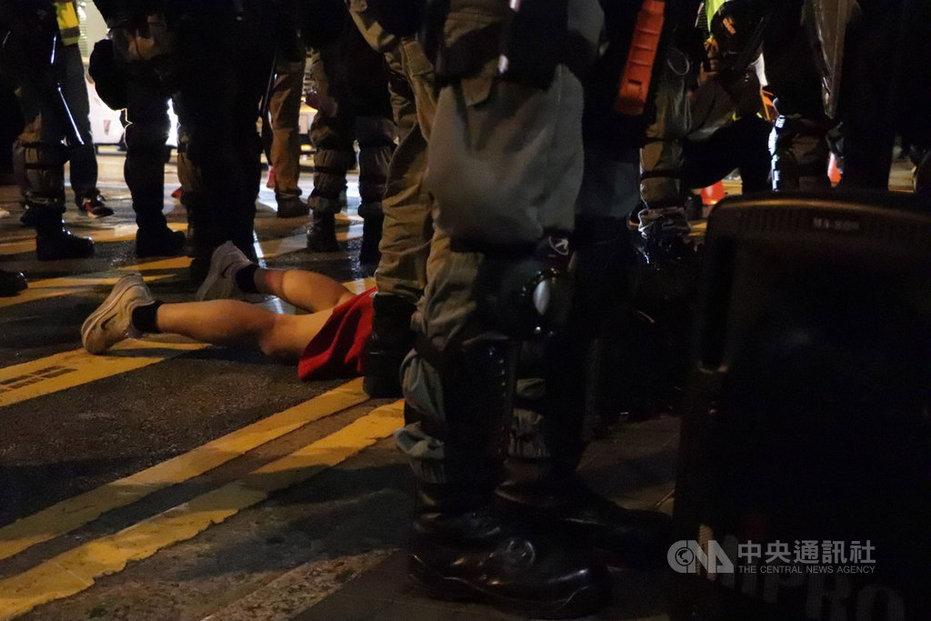 香港「反送中」網友趁著31日萬聖節之際發起集會遊行,許多人不顧禁蒙面法,戴著面具上街。圖為警方晚上9時30分左右在蘭桂坊附近先後逮捕了兩名示威者。中央社記者張謙香港攝 108年10月31日
