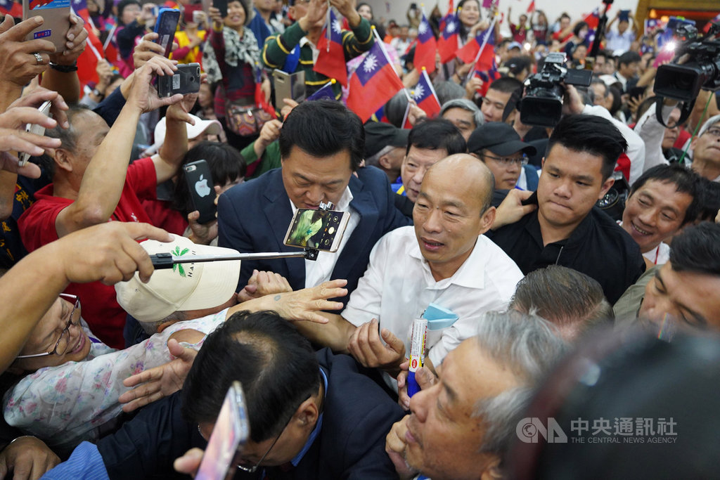 國民黨總統參選人韓國瑜(中白衣者)8日在台北出席「全國公教軍警消力挺韓國瑜暨黨籍立委」團結大會,在支持者簇擁下進場。中央社記者徐肇昌攝 108年11月8日