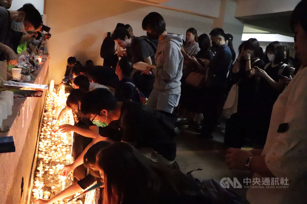 香港科技大學學生周梓樂日前墜樓後不治身亡。大批學生和市民8日晚間在事發地將軍澳尚德村停車場設立臨時靈台供人悼念、獻花,台前並點上白蠟燭。中央社記者張謙香港攝 108年11月8日