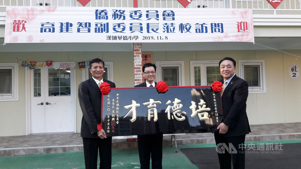 僑務委員會副委員長高建智(左)8日下午走訪漢城華僑小學,在駐韓代表唐殿文(中)的見證下,代表僑務委員長吳新興向學校董事長吳學彬(右)贈送校慶賀匾。中央社記者姜遠珍首爾攝 108年11月8日