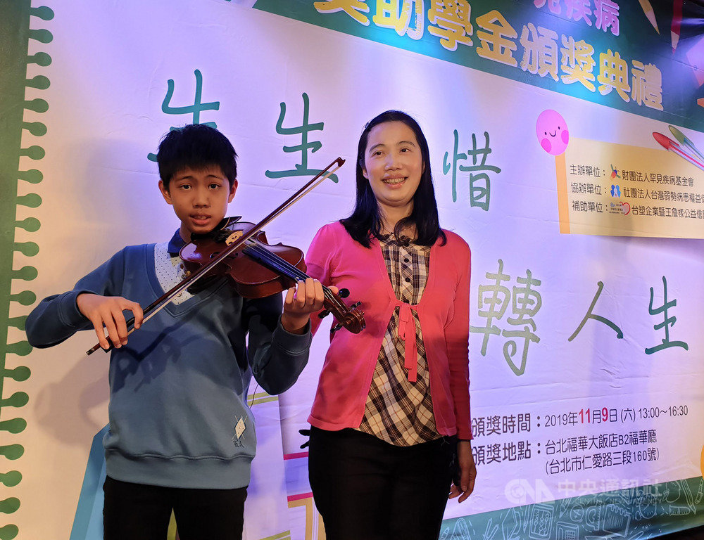 今年13歲的陳泓宇(左)罹患粒線體代謝異常,每天至少要睡12小時,是媽媽周曉君(右)的「無尾熊」男孩。周曉君9日受訪表示,陳泓宇自小學接觸到小提琴後,深深被琴聲吸引,開啟學習之路,對練習樂此不疲;且有音樂陪伴,也有助舒緩他的不適。中央社記者陳偉婷攝 108年11月9日