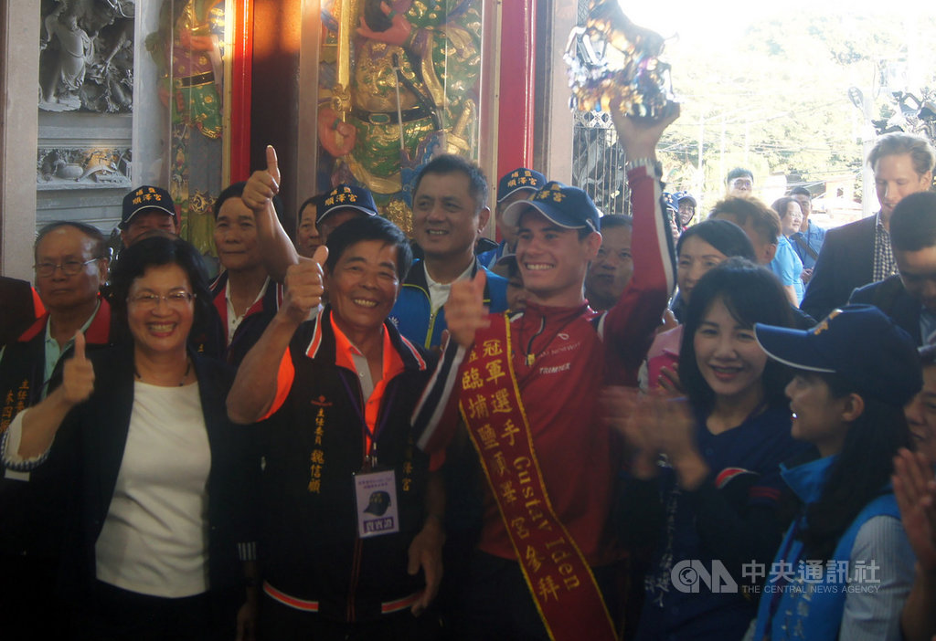 挪威三鐵選手艾登(Gustav Iden)(前左3)9日造訪彰化埔鹽順澤宮還願,廟方特別贈送名為「一鹿領先」的琉璃雕像,現場熱情民眾更高呼Champion(冠軍),氣氛相當熱鬧。前左起為彰化縣長王惠美、順澤宮主委魏信顧。中央社記者吳哲豪彰化攝 108年11月9日