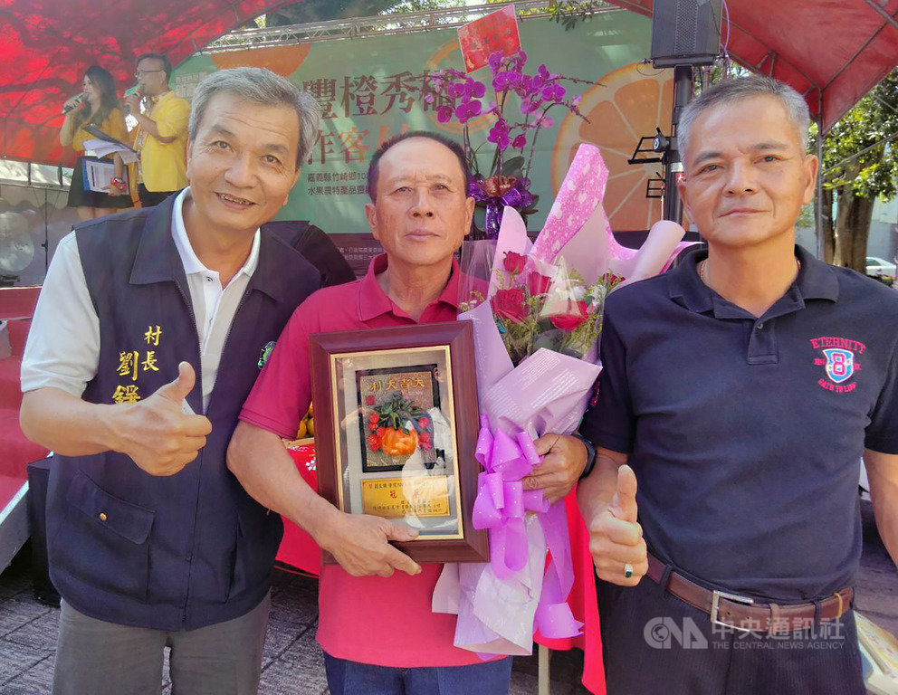 嘉義縣竹崎鄉9日在鹿滿客家文化園區舉行水果農特產暨觀光行銷活動,並頒獎表揚椪柑評鑑冠軍農民劉文錦(前中),劉文錦也開心捧著花束獎牌留影。中央社記者蔡智明攝 108年11月9日