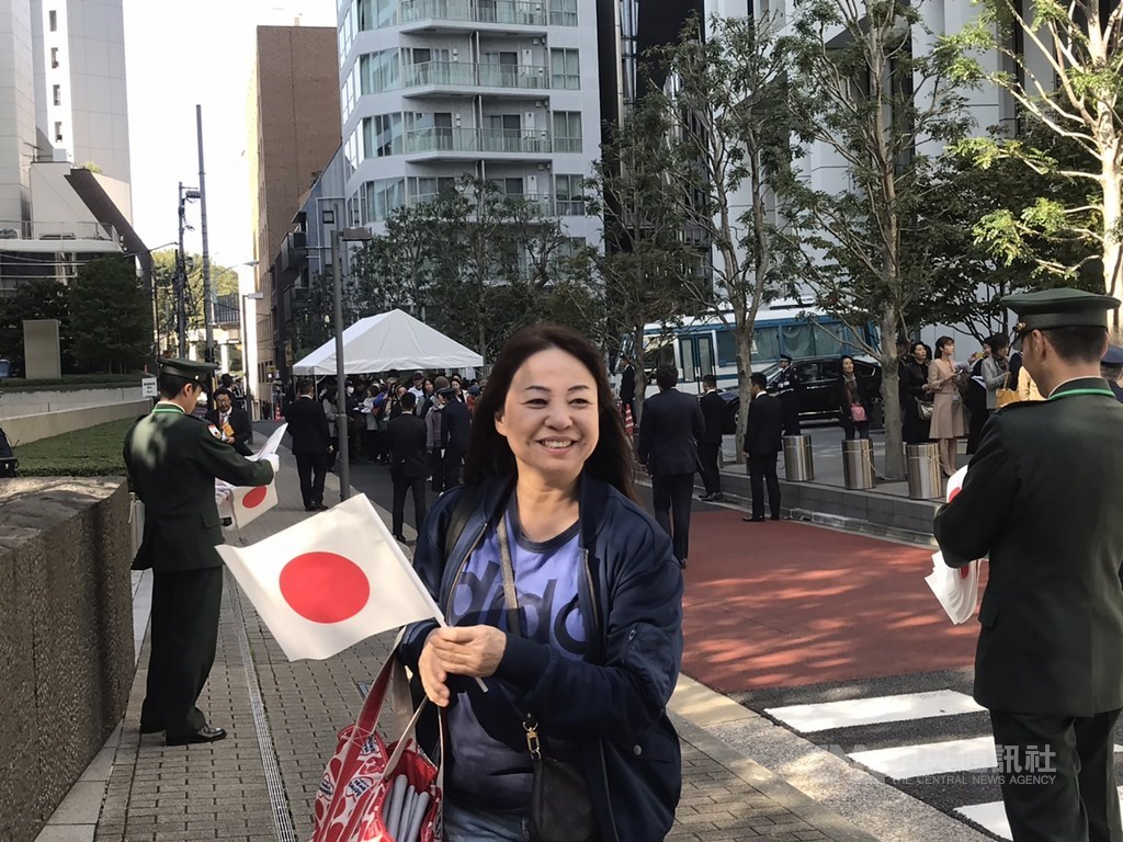 日皇德仁即位遊行「祝賀御列之儀」10日下午登場,不少民眾提前在遊行路線附近排隊,圖為一位女士拿著日本國旗興奮等待。中央社記者楊明珠東京攝 108年11月10日