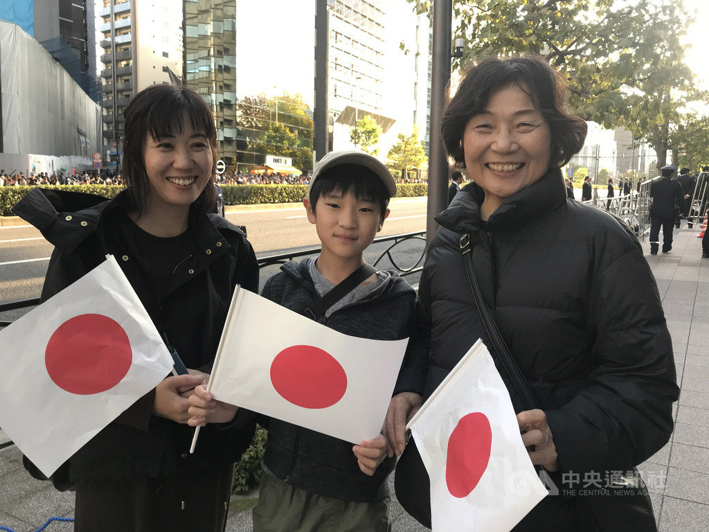 慶祝日皇德仁5月1日即位,10日舉辦慶賀遊行,沿途近12萬民眾揮國旗歡呼。11歲富田小弟弟(中)與祖母(右)、母親(左)在赤坂見附一帶揮小國旗同慶。中央社記者楊明珠東京攝 108年11月10日