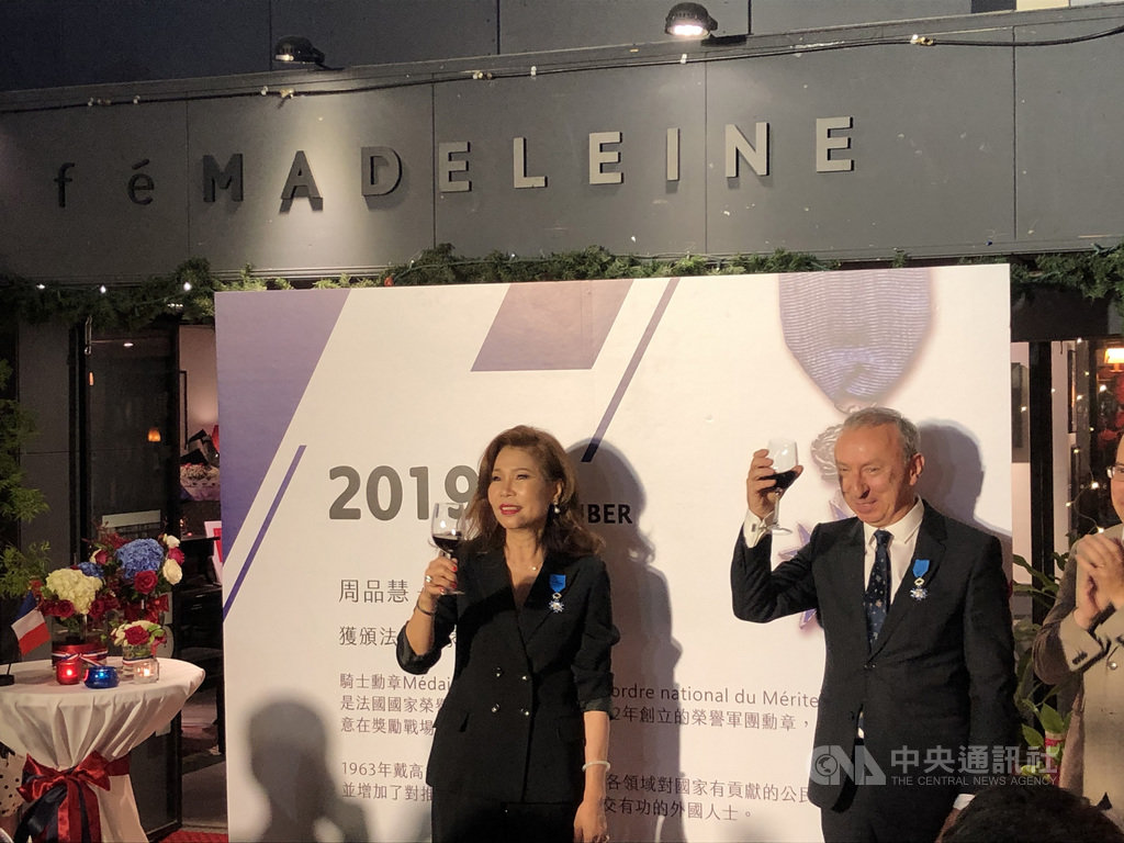 法國在台協會主任公孫孟(右)12日代表法國政府,頒發法國國家功勳騎士勳章給瑪德蓮小酒館主人周品慧(左),肯定她對台法文化交流的貢獻,兩人也一同舉杯慶祝。中央社記者侯姿瑩攝 108年11月12日