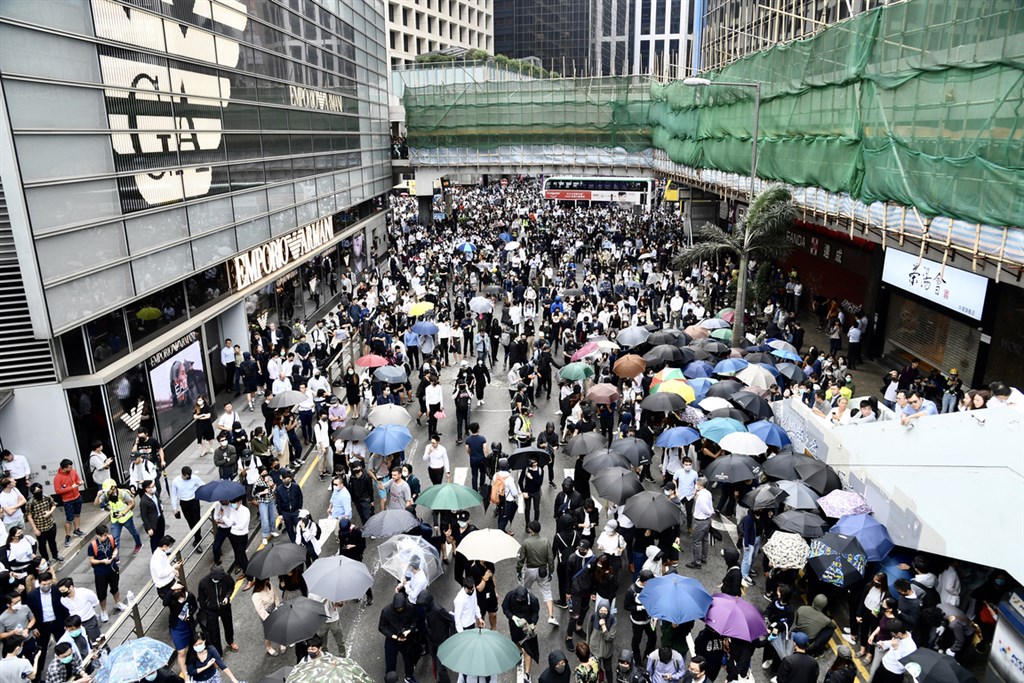 大批反送中黑衣蒙面示威者12日中午聚集於香港中環德輔道中,破壞馬路指示燈,以雜物堵路,塗污巴士車窗並焚燒雜物,交通宣告癱瘓。(中通社提供)中央社 108年11月12日