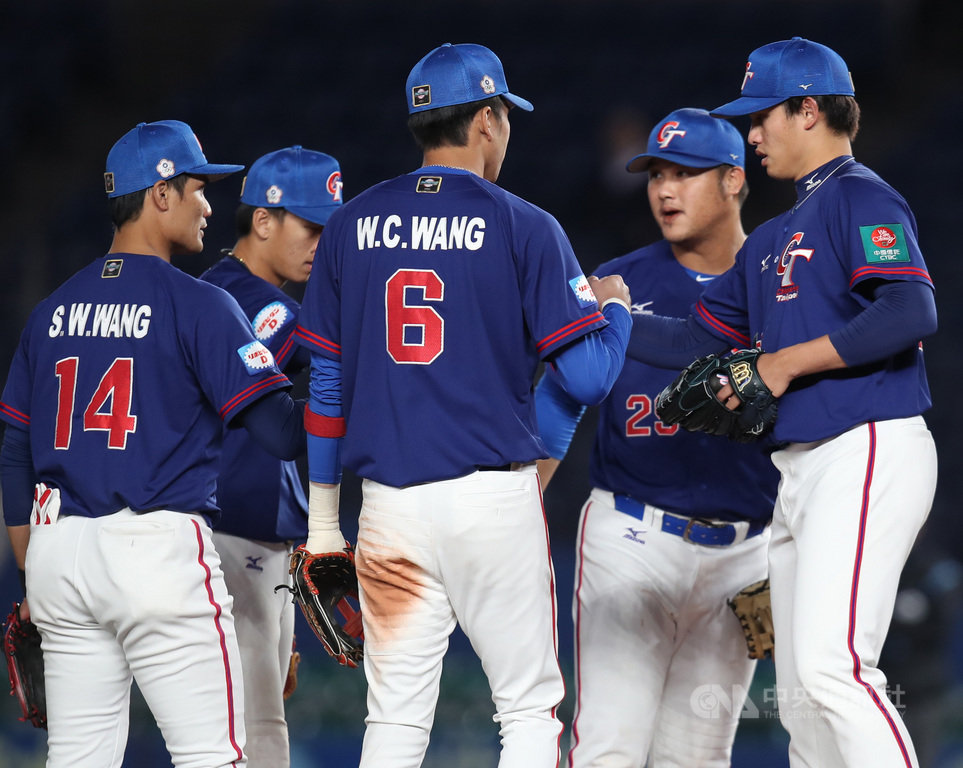2019世界12強棒球賽複賽,中華隊12日晚間在日本千葉ZOZO球場對戰韓國隊,7局下2人出局時,中華隊先發投手張奕(右)下場,由左投陳冠宇接手,順利化解二壘有人的危機。張奕先發投6.2局,退場前與場上隊友一一擊拳。中央社記者張新偉千葉攝 108年11月12日