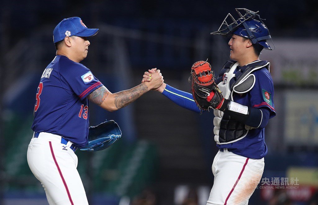 2019世界12強棒球賽複賽,中華隊12日晚間在日本千葉ZOZO球場交手韓國隊,9局下終結者陳鴻文(左)送出2次三振無失分,幫助球隊守住勝利。賽後與捕手高宇杰(右)握拳致意。中央社記者張新偉千葉攝 108年11月12日