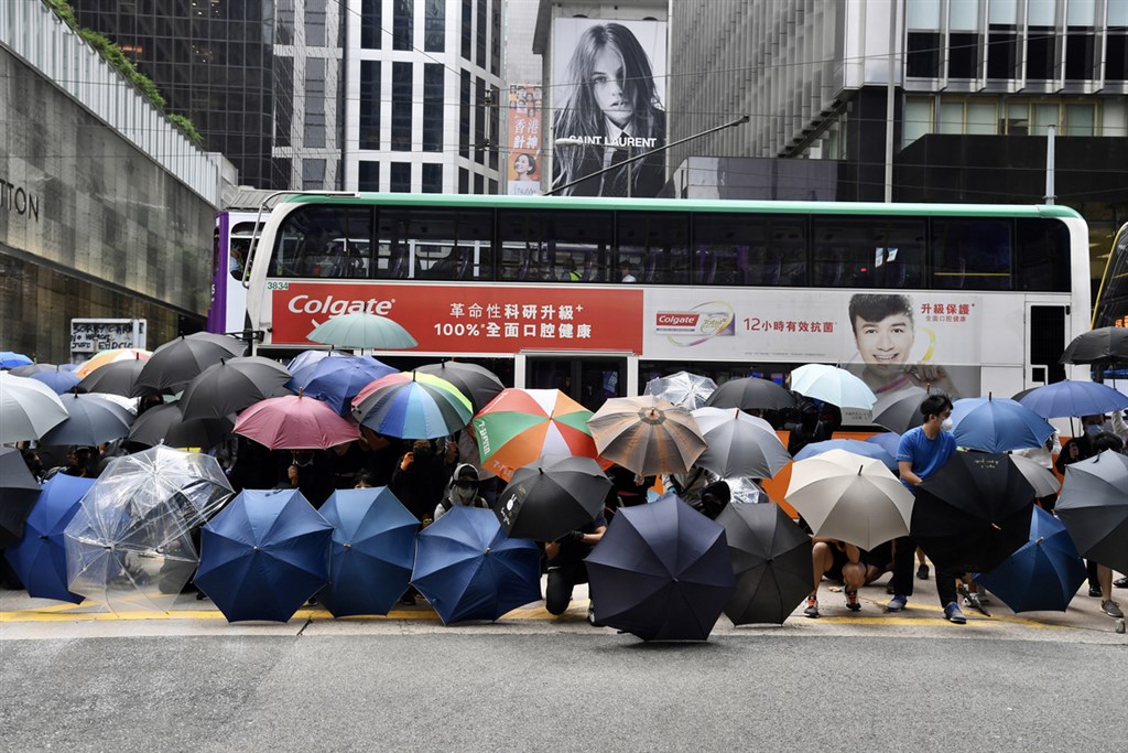 香港「反送中」支持者12日連續第2天發起「三罷」,多名示威者中午在中環鬧區以傘陣堵路。(中通社提供)