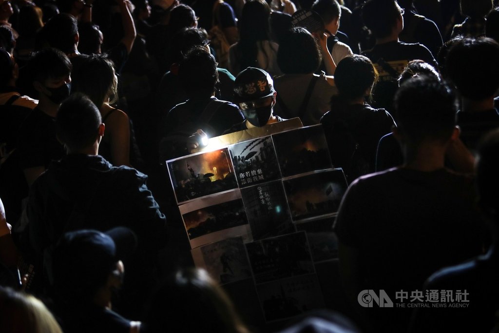 撐香港要自由演唱會17日晚間在台北自由廣場登場,不少人帶著各式旗幟、標語等到場響應,有與會民眾在人群中手持貼滿香港抗爭過程照片的看板,表態力挺香港反送中運動。中央社記者吳家昇攝 108年11月17日