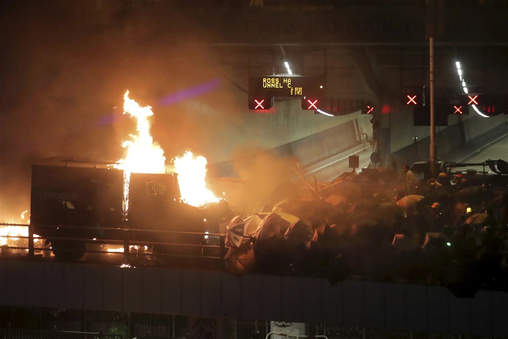 香港反送中抗爭迄今5個月,17日晚間首度出現銳武裝甲車,在理工大學旁的暢運道推進驅離示威者時,遭汽油彈擊中起火燃燒。(美聯社)