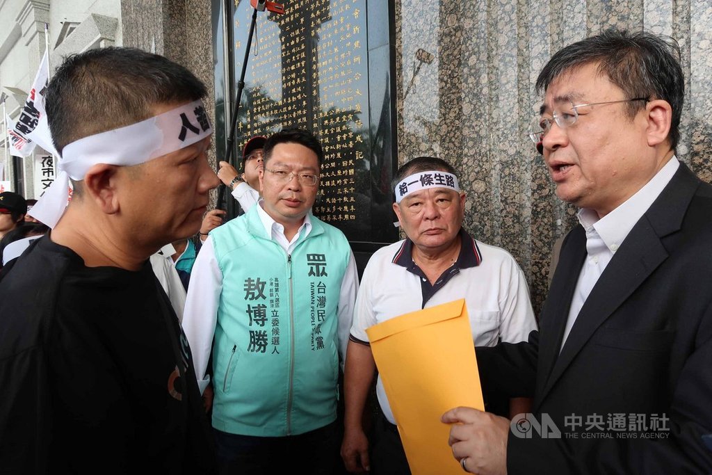 高雄市一德夜市落日條款已生效,市府動員警力執法禁擺攤引發不滿,百餘攤商20日到市議會陳情暫緩取締,也批評市府未輔導讓他們生計陷困境。經發局長伏和中(右)接下陳情書,並允諾再協調輔導。中央社記者王淑芬攝 108年11月20日