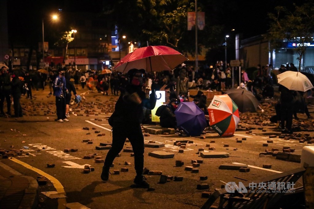 香港理工大學內的反送中示威者持續被港警包圍,18日深夜示威者在尖東一帶占據馬路,與警方對峙,有示威者朝港警方向丟擲磚塊。中央社記者吳家昇攝 108年11月19日