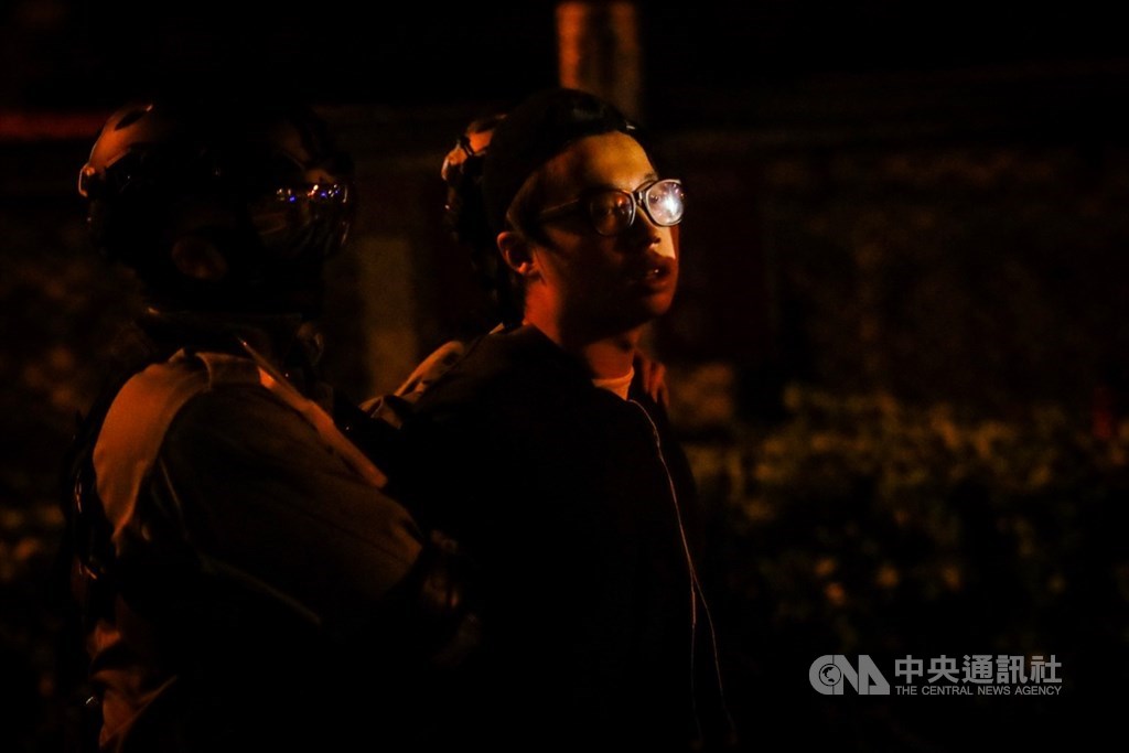 近來反送中爆發激烈警民衝突,警方從11月18日起包圍理工大學,並在校區外設防線,逾10名示威者19日深夜欲闖出防線,遭警方制服,隨後帶上警車。中央社記者吳家昇攝 108年11月20日