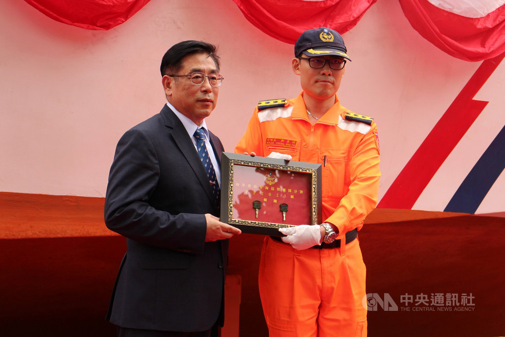 海巡署艦隊分署金門海巡隊2023艇,戌守海疆多年後退役,22日舉行移撥揭牌儀式,金門海巡隊分隊長鄭書羽(右)將鑰匙交給海洋委員會政務副主任委員莊慶達(左),象徵快艇功成身退,正式除役。中央社記者黃慧敏攝 108年11月22日