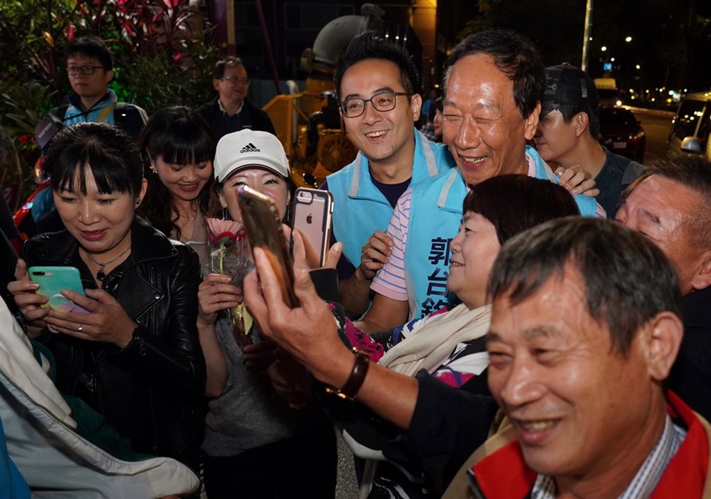 鴻海集團創辦人郭台銘(藍色背心右)22日晚間陪新北市立委第10選區參選人李縉穎(藍色背心左)掃街拜票,受到民眾歡迎,爭相上前要求合影。(李縉穎競選辦公室提供)中央社記者黃旭昇新北市傳真 108年11月22日