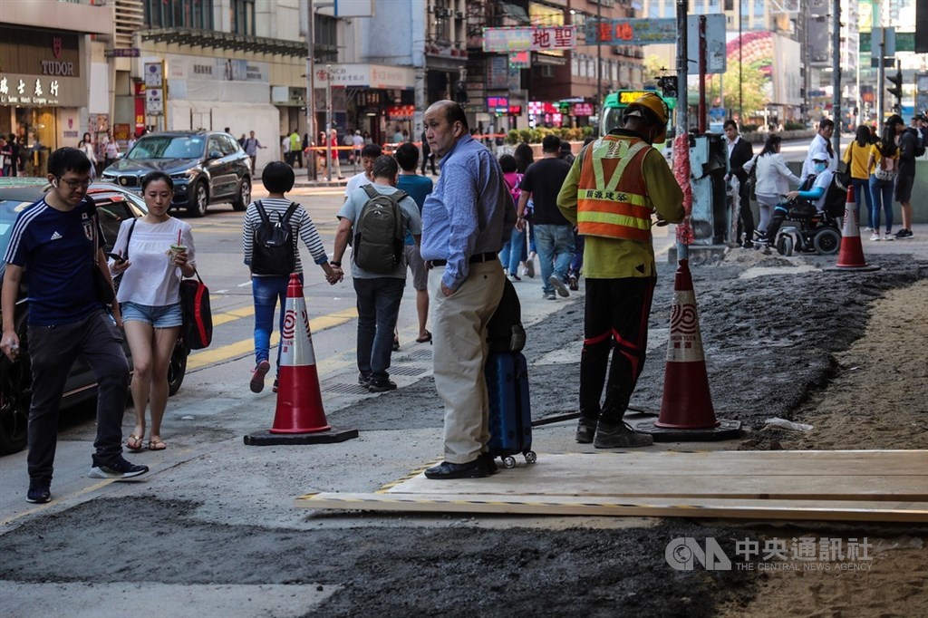 近來香港反送中爆發多次激烈警民衝突,香港多處人行道磚被示威者挖起,滿目瘡痍,22日工程人員重新施工,填補受損人行道。中央社記者吳家昇攝 108年11月22日
