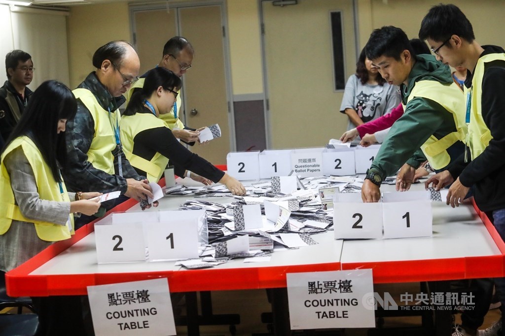 香港近日抗爭情勢逐漸趨緩,24日區議會選舉如期舉行,晚間10時30分結束投票後進行點票作業,灣仔一家投票站工作人員25日凌晨仔細清點選票。中央社記者吳家昇攝 108年11月25日