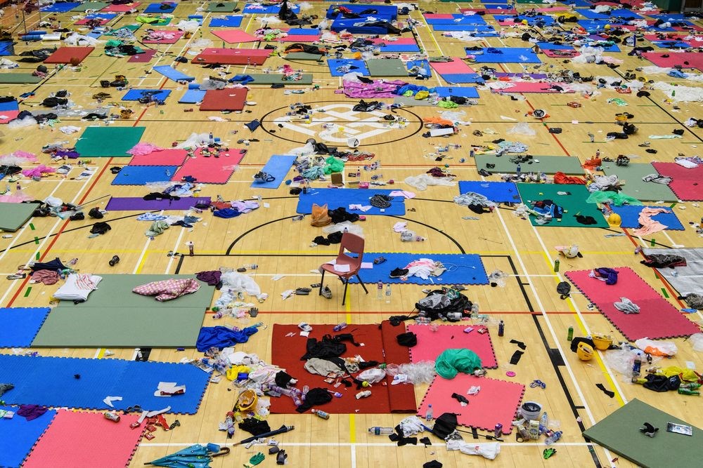 據香港媒體報導,1名留守理工大學的人28日凌晨1時許離開校園,並聲稱當時裡面至少有1至3名留守者。圖為理工大學體育館內散布示威者留下的防護裝備、衣物。(法新社提供)