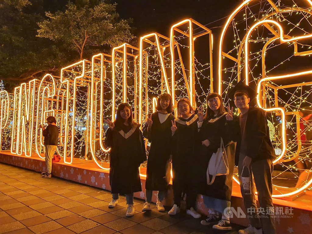 「2019屏東聖誕節」點燈活動29日晚間起正式展開,屏東縣府在百年屏東公園打造奇幻童話世界,夜間燈光亮起後,浪漫景致美不勝收,吸引大學生到場拍畢業照。中央社記者郭芷瑄攝 108年11月29日