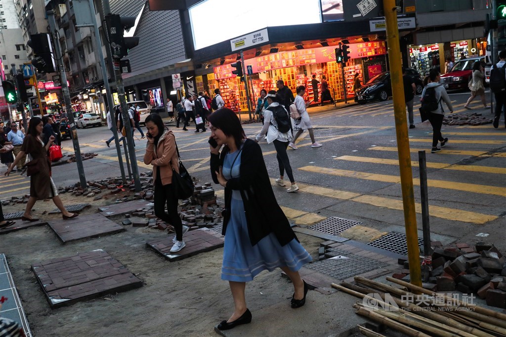 反送中衝突讓尖沙咀鬧區不少人行道受到損毀,民眾穿梭在遭破壞的人行道上,修復工程也正陸續進行。 中央社記者吳家昇攝108年11月20日