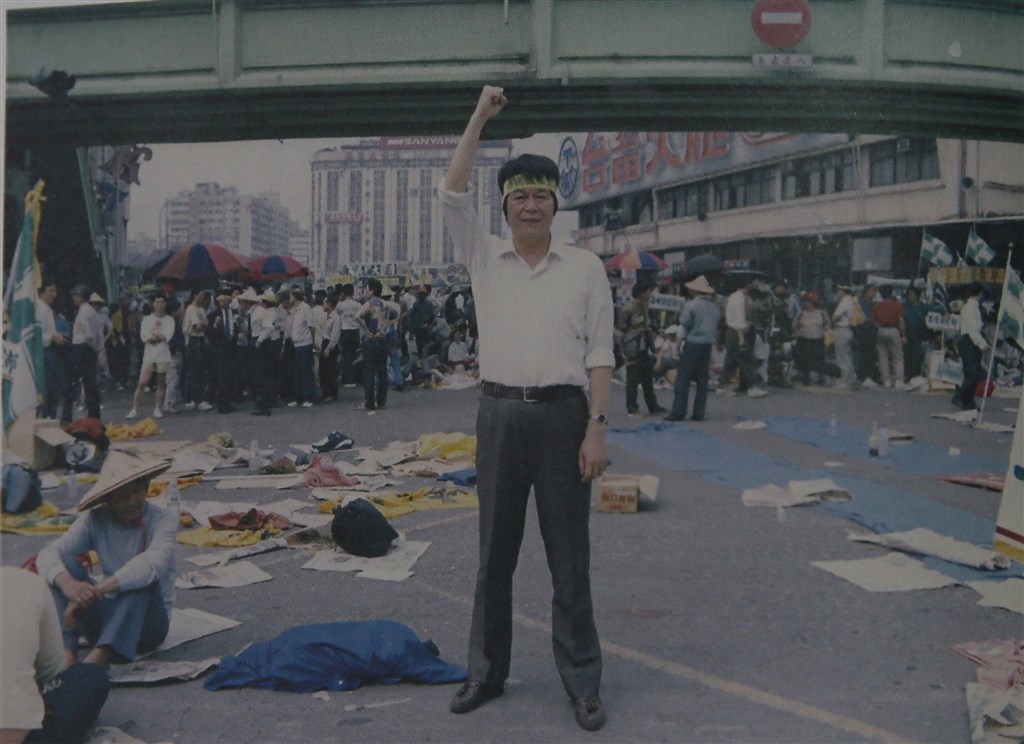 1992年民進黨要求國民黨政權總統直選,紀萬生頭上綁布條「總統直選」於台北火車站前。(紀萬生提供)