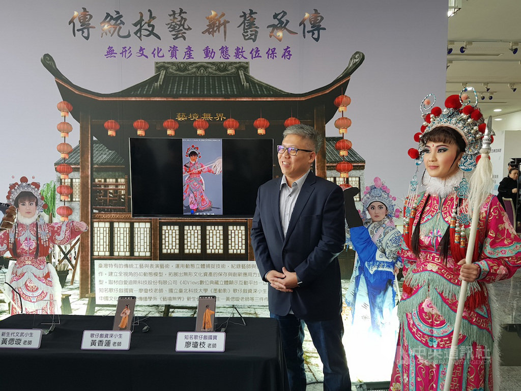 文化部在前瞻計畫支持下打造IP內容實驗室,從法國引進最新的4DViews動態立體虛擬攝影系統,3日舉行分享會,現場以行動裝置呈現歌仔戲4D模型,新生代歌仔戲演員黃偲璇(右)也特別以全身裝扮親臨展示區,展現虛實互動。中央社記者鄭景雯攝 108年12月3日