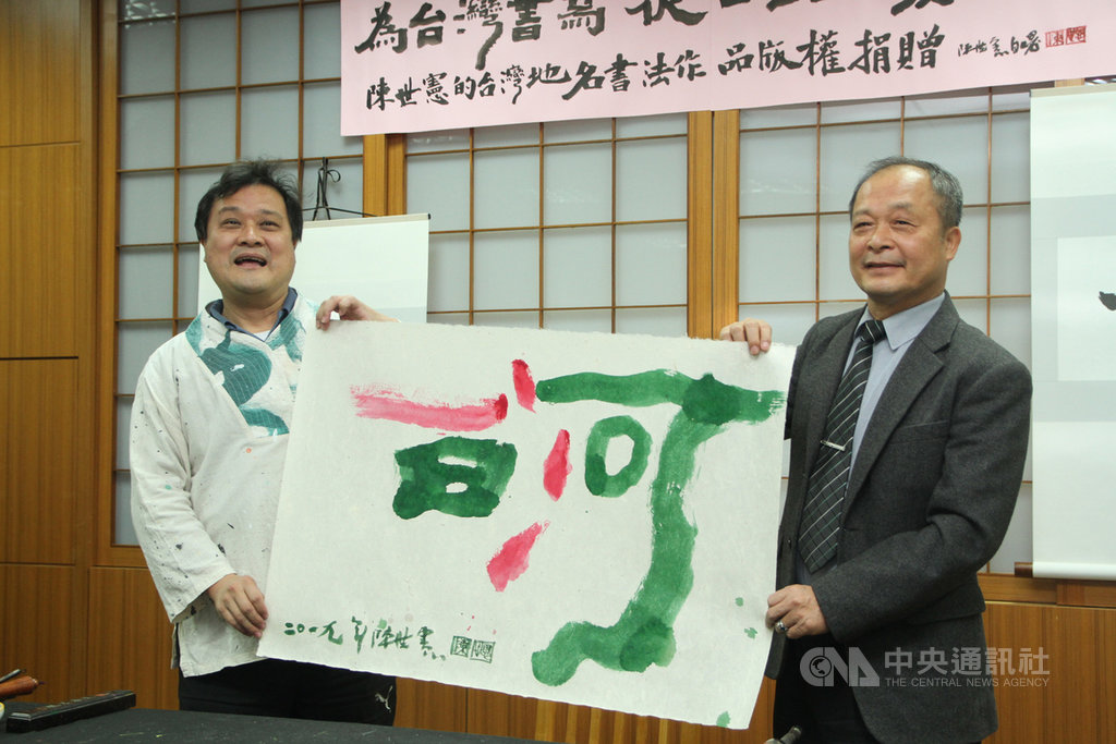 知名意象書法家陳世憲(左)3日在台南市白河區公所宣布捐出以「地誌書法」創作的台灣地名作品版權,並現場揮毫「白河」二字,由白河區長蕭福清(右)代表區公所受贈。中央社記者楊思瑞攝 108年12月3日