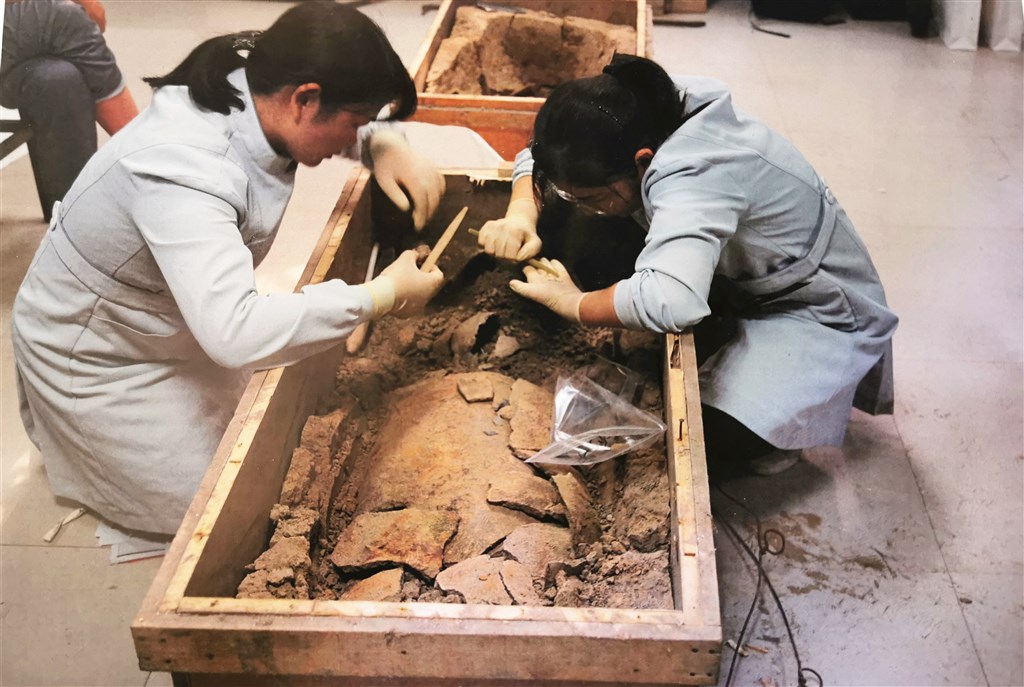 中國絲綢博物館、鄭州市文物考古研究院3日表示,滎陽仰韶文化遺址發現的絲織物,是目前中國發現的最早的絲織品。圖為考古人員從甕棺中提取碳化絲織品。(中新社提供)