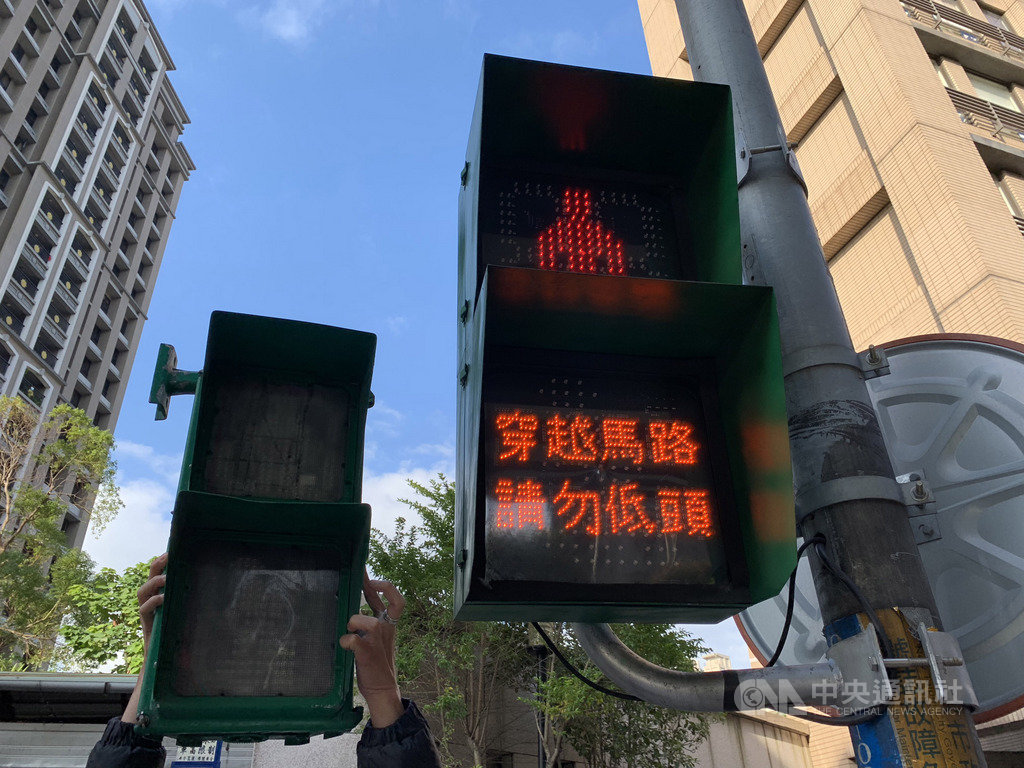 新北市政府交通局設置放大型小綠人號誌燈,其中雙和醫院前的號誌燈更是全國最大支,紅燈時還會顯示「穿越馬路,請勿低頭」警示標語,讓年長者行得更安全。(新北交通局提供)中央社記者葉臻傳真 108年12月4日