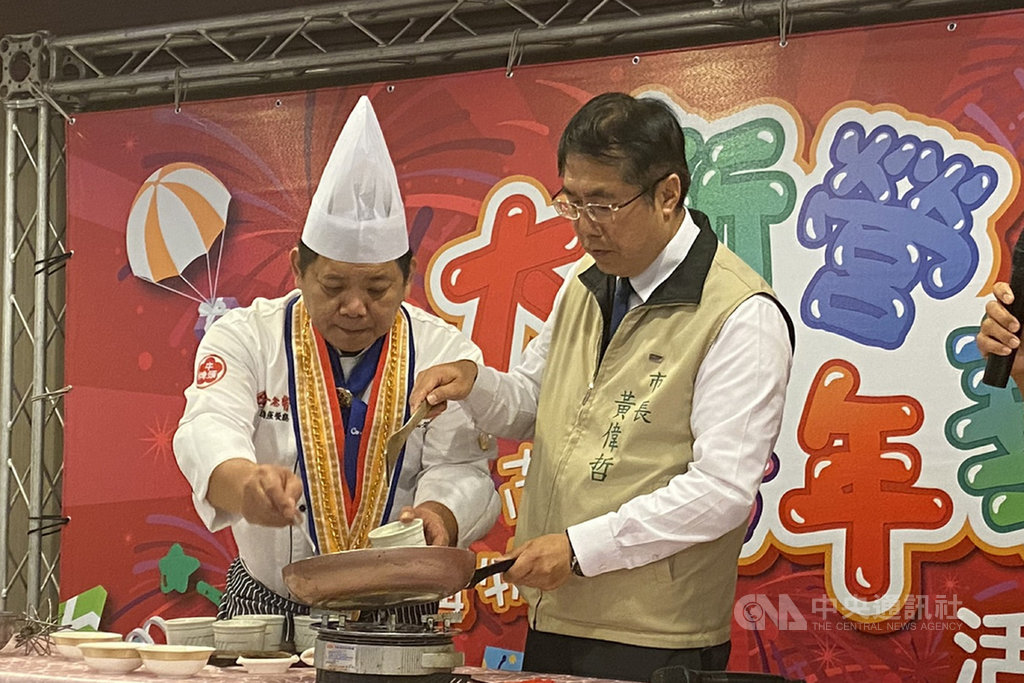台南市長黃偉哲(右)4日出席2019台南購物節大新營嘉年華活動記者會,陪同廚師現場示範料理,力薦新營美食。中央社記者楊思瑞攝 108年12月4日