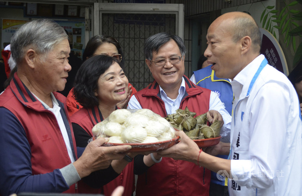 國民黨總統參選人韓國瑜(右)4日走訪嘉義市,頂庄里長莊天基(左)送上里民包的包子與粽子,祝韓國瑜高票當選。中央社記者蔡智明攝 108年12月4日