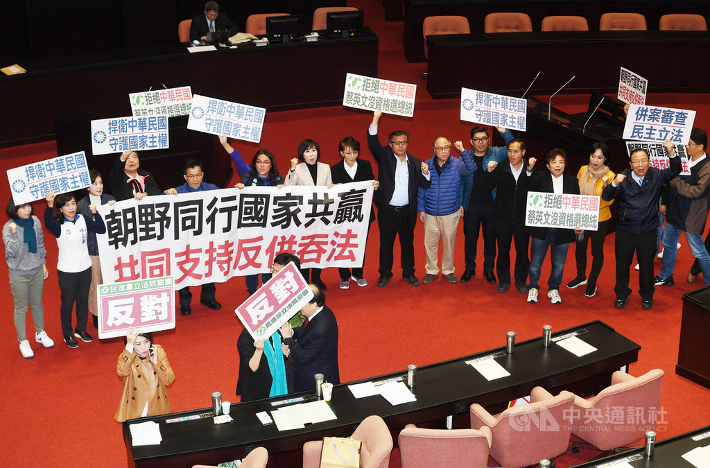 立法院會6日處理國民黨立法院黨團(後排)所提的反併吞中華民國法草案逕付二讀,與民進黨團版的反滲透法草案併案協商。因民進黨團(前排)舉牌反對,經表決後提案不通過,草案交內政委員會審查。中央社記者施宗暉攝 108年12月6日