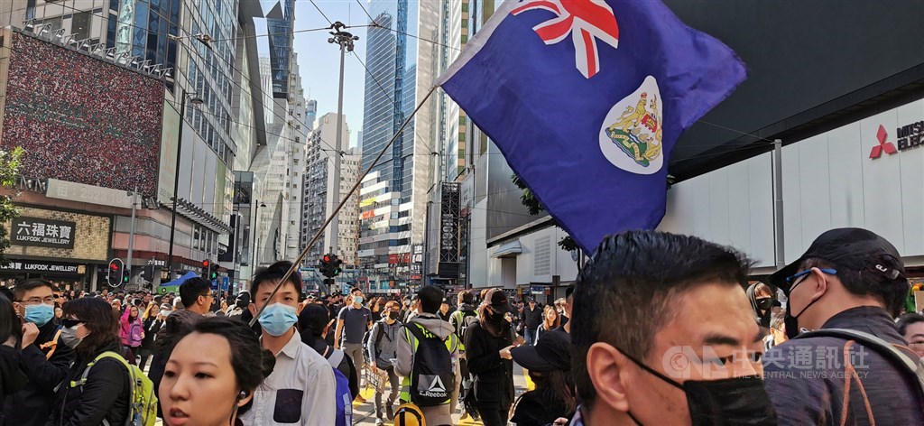香港民陣8日下午再次號召民眾上街,繼續反送中相關訴求,圖為遊行剛開始,銅鑼灣一帶人潮,有人手持港英政府旗幟。中央社記者張謙香港攝 108年12月8日