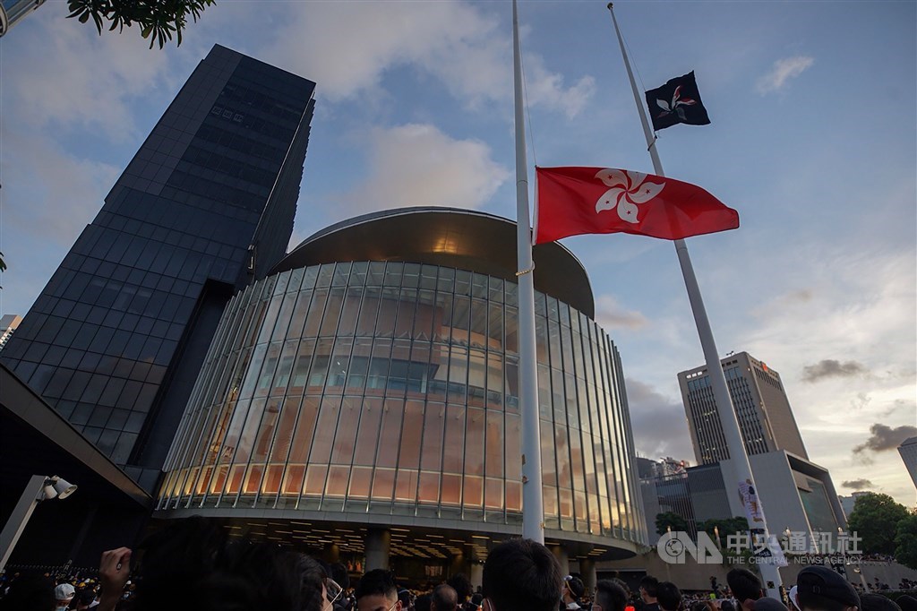 圖為反對逃犯條例修訂的香港民眾7月1日在立法會外升起黑色香港區旗。(中央社檔案照片)