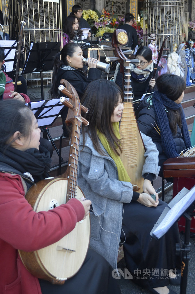 嘉義民族管弦樂團與三昧堂跨界合作,8日上午在阿里山受鎮宮演出,氣溫接近攝氏零度,彈琵琶的團員林孟婷(左2)還用暖暖包暖手指,她說,沒在這麼冷的天氣彈過琵琶,手都凍僵了。中央社記者蔡智明攝 108年12月8日