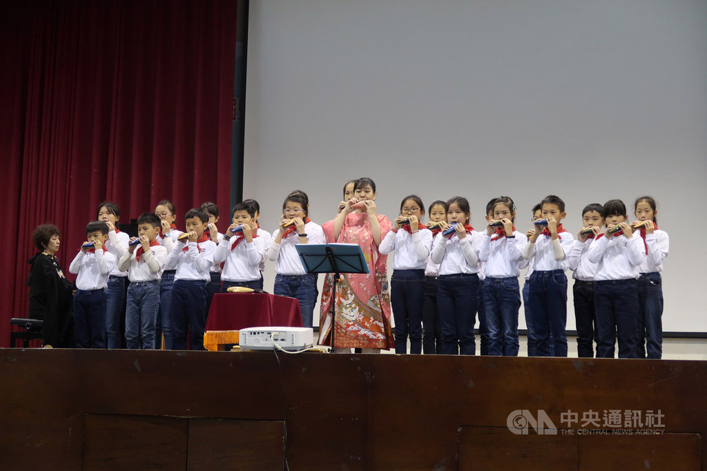 日本陶笛演奏家河崎敦子(中粉色和服者)與鋼琴演奏家巨勢典子(左黑衣者)9日應邀到台中市協和國小參與「台日交流陶笛音樂會」,與學子攜手演出。(協和國小提供)中央社記者蘇木春傳真 108年12月9日