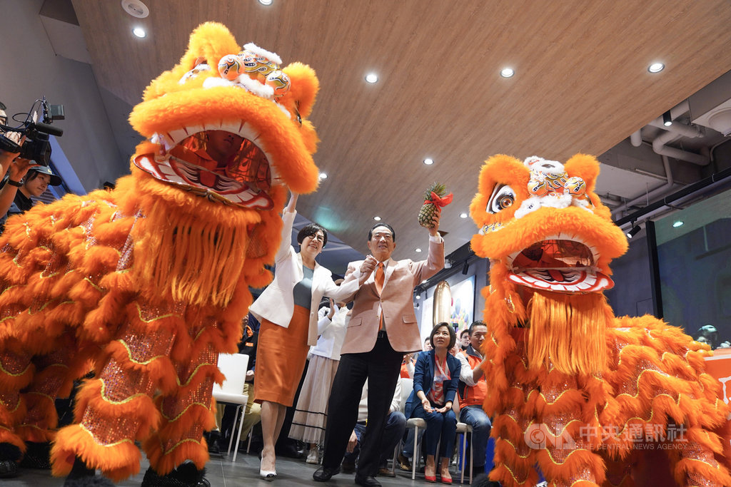 親民黨總統參選人宋楚瑜(前右)與副總統參選人余湘(前左)全國競選總部10日在台北市正式開張,宋楚瑜從舞獅口中接下鳳梨,象徵好運旺旺來。中央社記者徐肇昌攝 108年12月10日