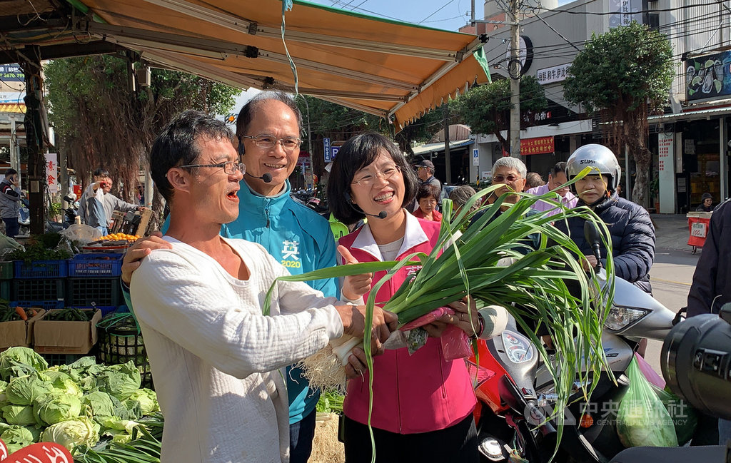 前行政院長游錫堃(前中)11日陪同尋求連任的民進黨新北市第5選區立委參選人蘇巧慧(前右)至鶯歌建國市場拜票,與攤販捧蒜合影,高喊凍蒜。中央社記者葉臻攝 108年12月11日