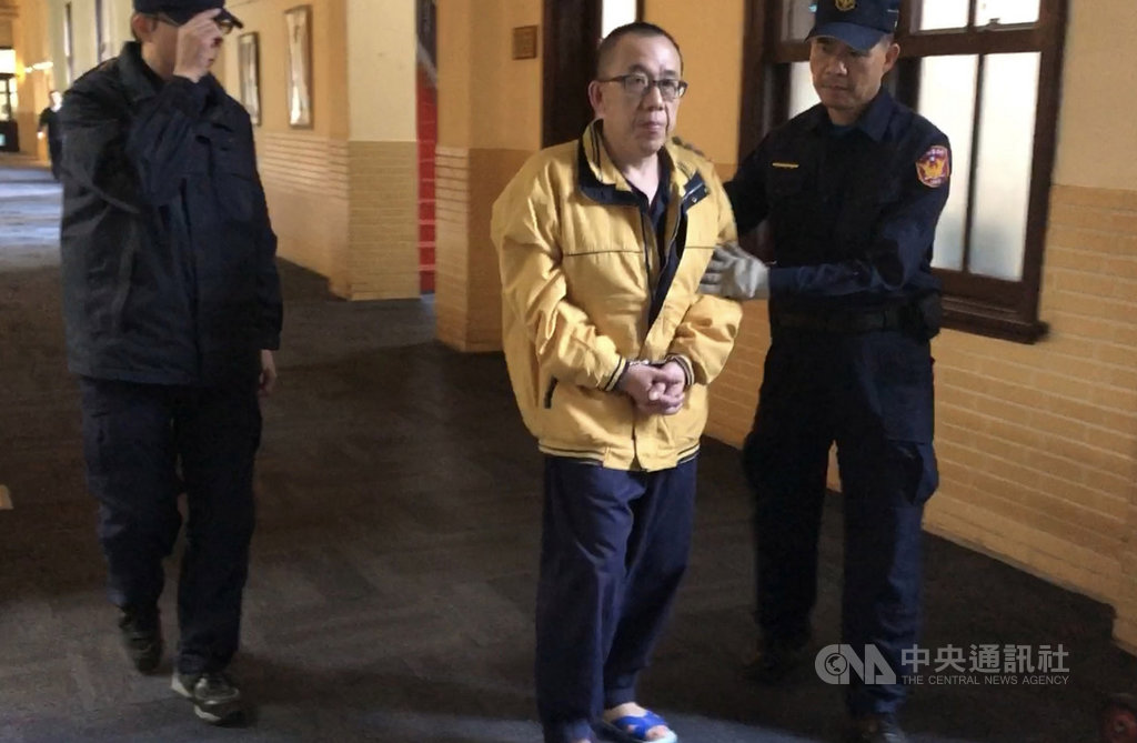 桃園男子詹賢明(中)被控徒手勒斃擔任空姐的簡姓妻子,一審遭判15年,經上訴,二審12日開庭,詹男認罪並請求自首應可減刑,但死者弟妹庭上控訴詹男蓄意謀殺應重判。圖為詹男庭後還押。中央社記者劉世怡攝 108年12月12日