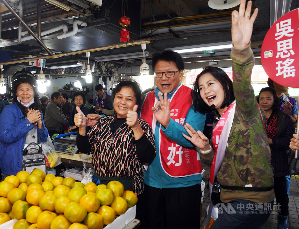 屏東縣長潘孟安(前右2)14日上午陪同民進黨台北市立委第1選區(北投、士林)參選人吳思瑤(前右)在北投市場掃街拜票,與攤商熱情合影。中央社記者施宗暉攝 108年12月14日