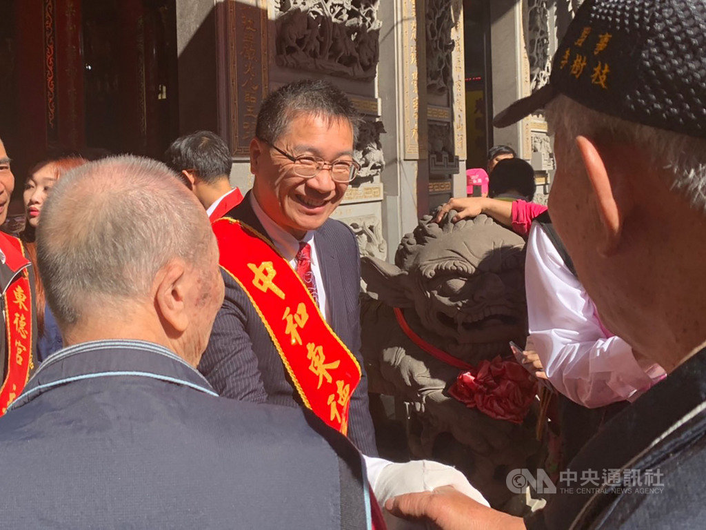 內政部長徐國勇(中)15日出席中和東德宮揭匾典禮,與現場民眾握手、互動熱絡。中央社記者葉臻攝 108年12月15日
